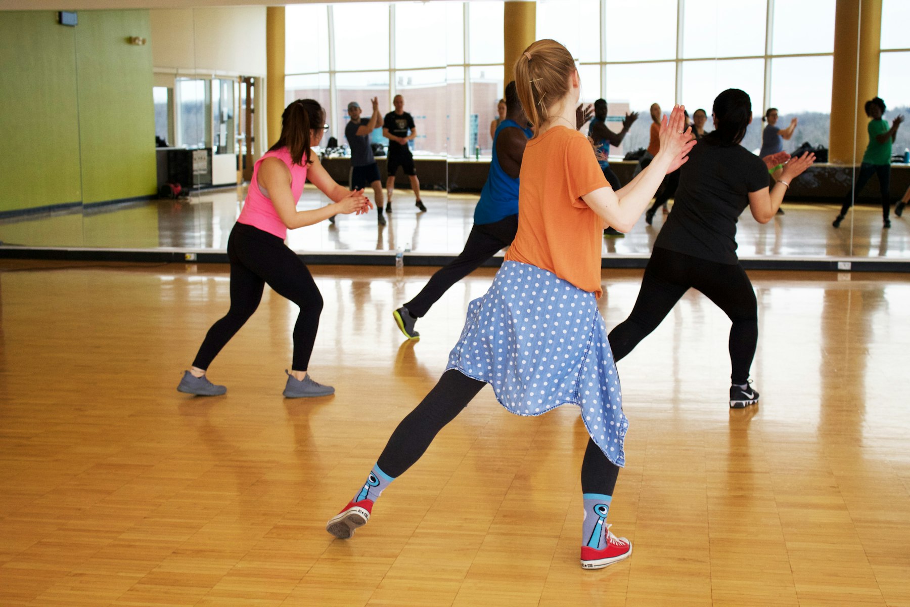 An energetic group dance class in a mirrored studio